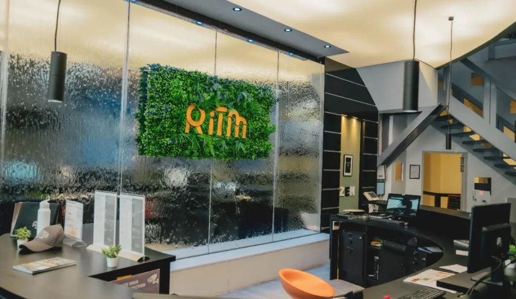 Accueil du campus IPMS avec mur végétalisé et logo, reflétant un environnement moderne et convivial.