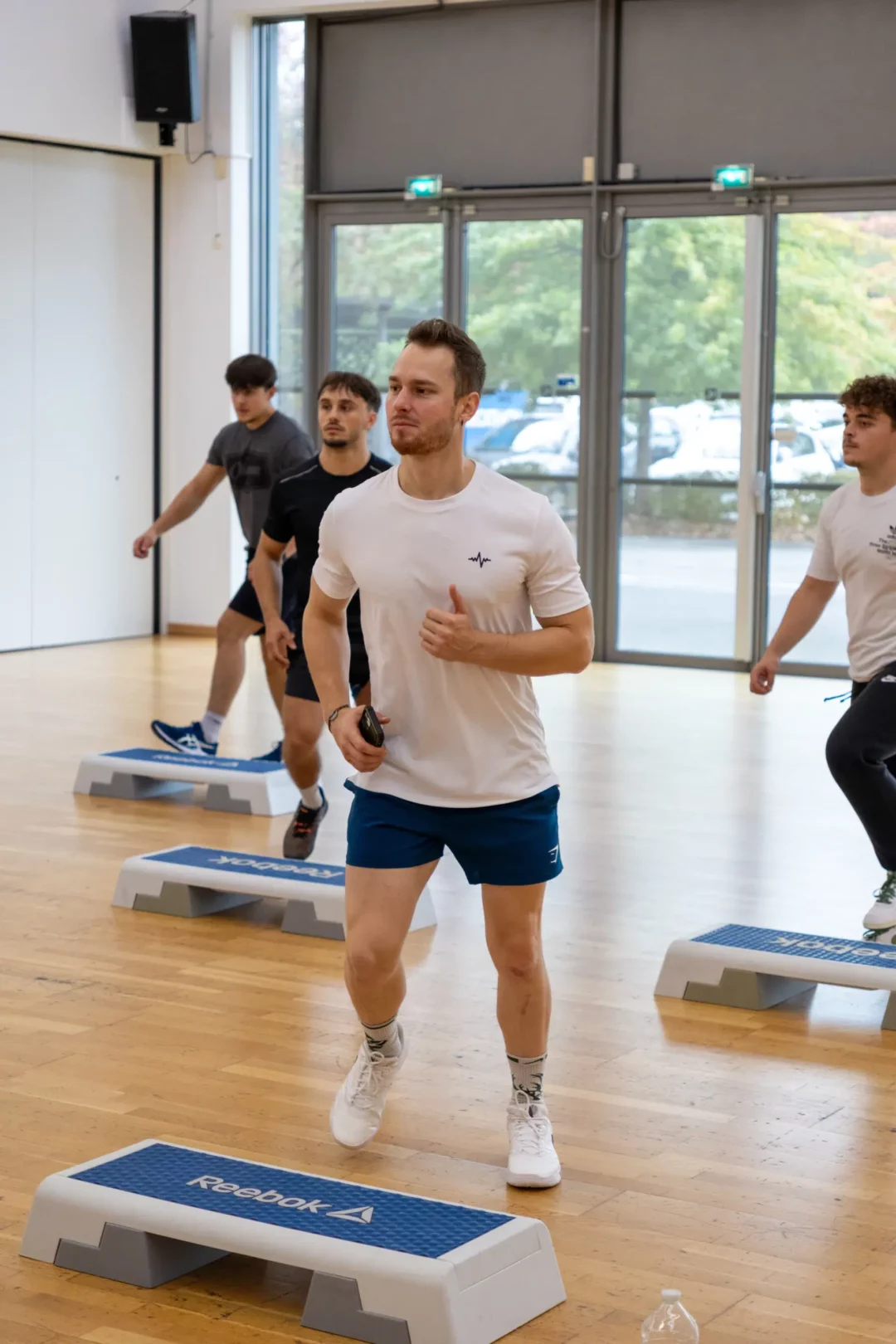Stagiaires en formation BPJEPS AF lors d'un cours collectif de step dans une salle de fitness