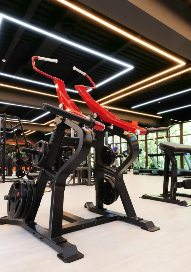 Salle de remise en forme moderne équipée de machines guidées et plateaux cardio, vue d’ensemble lumineuse.