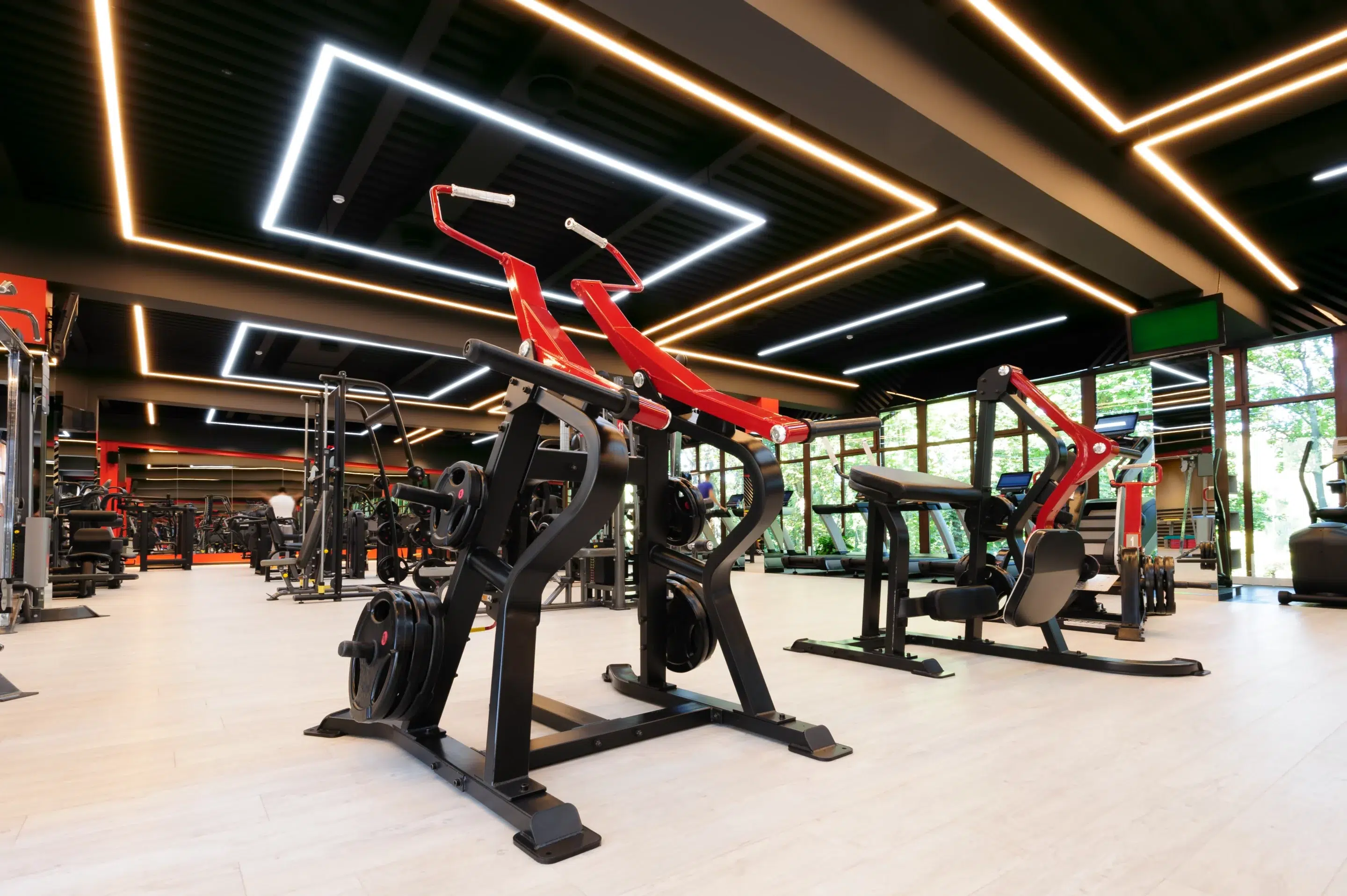 Salle de remise en forme moderne équipée de machines guidées et plateaux cardio, vue d’ensemble lumineuse.