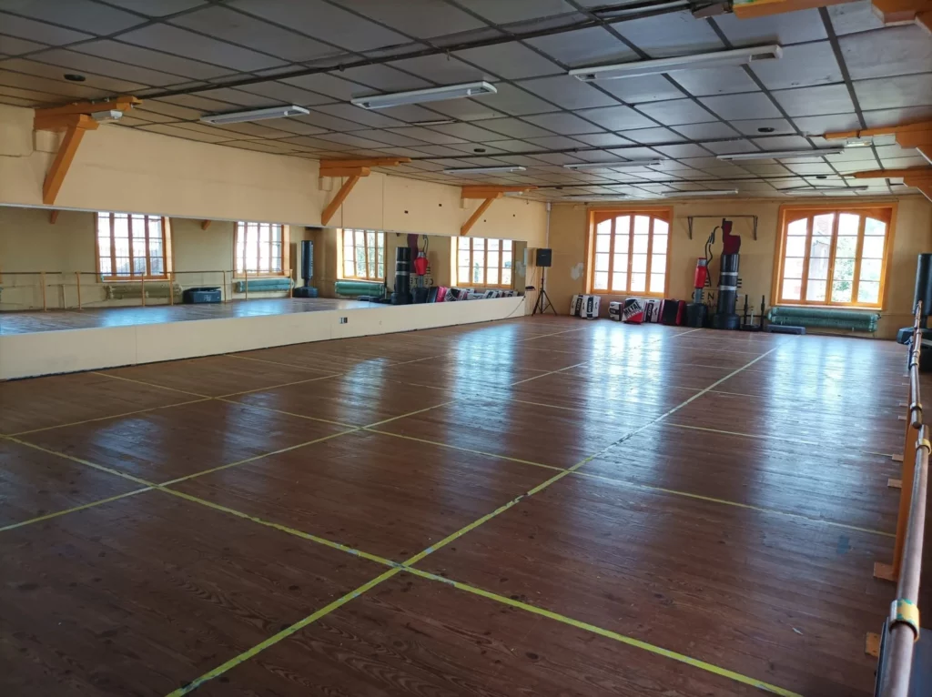 Grande salle de cours collectifs IPMS Limoges avec parquet et miroirs.
