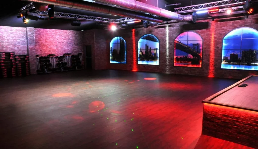 Salle de cours collectifs IPMS Strasbourg avec lumière rouge et décor urbain.