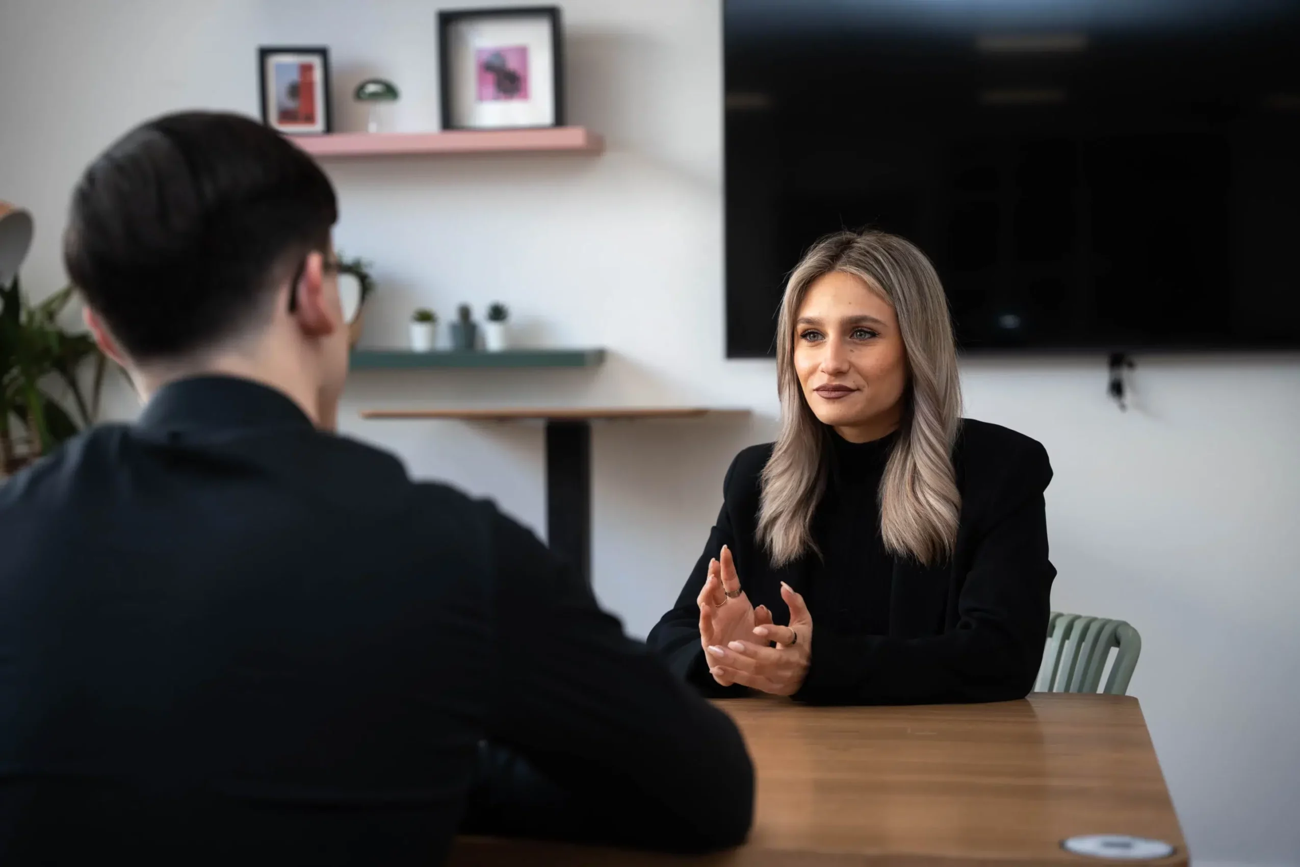 Professionnelle en entretien commercial avec un client dans un environnement de bureau moderne