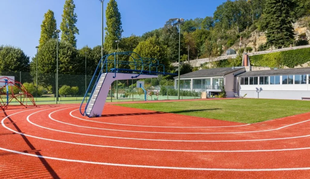 Terrain extérieur multi-activités IPMS avec piste et structure de jeu.