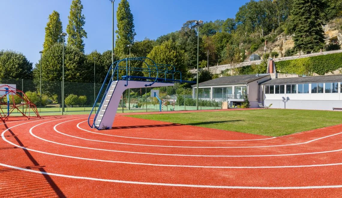 Terrain extérieur multi-activités IPMS avec piste et structure de jeu.