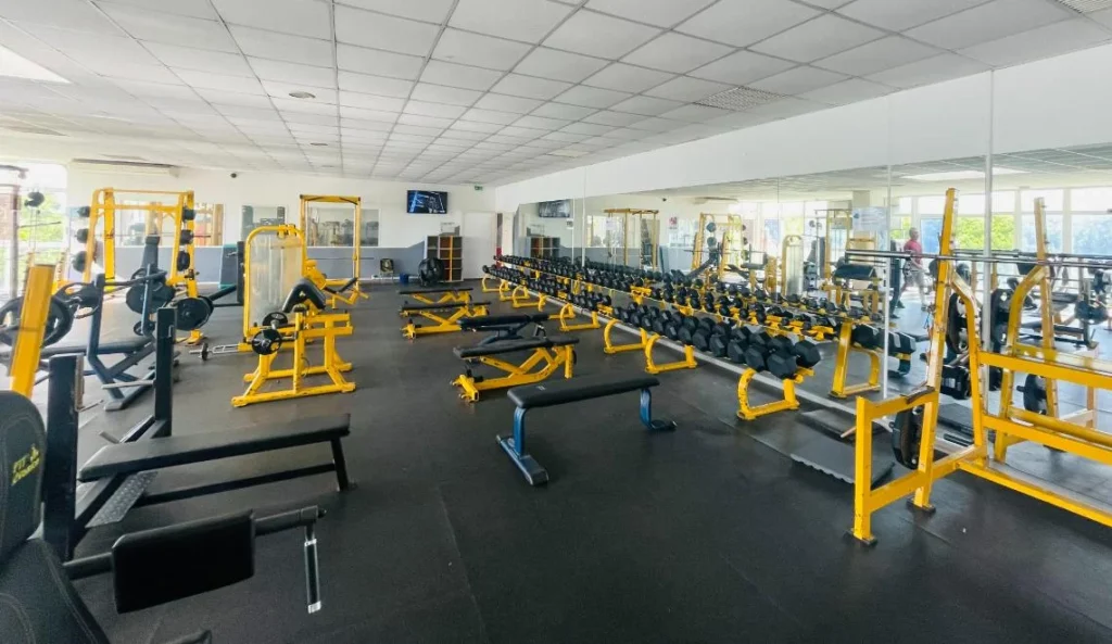 Vue large du plateau musculation IPMS Saint-Louis avec bancs, haltères et machines guidées.