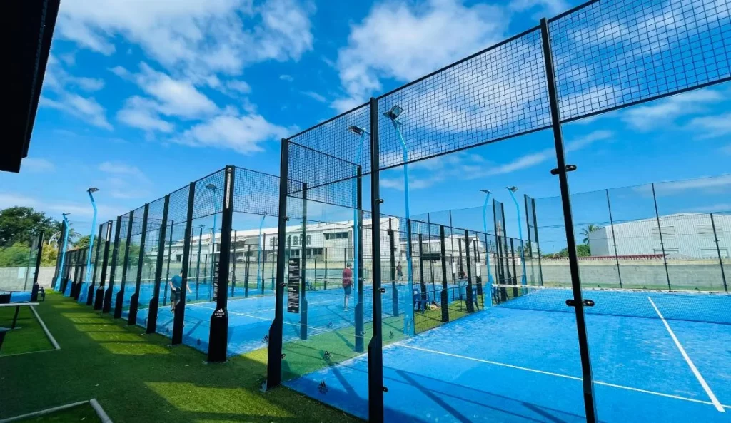 Terrains de padel IPMS Saint-Louis en extérieur, surface bleue et clôtures vitrées.