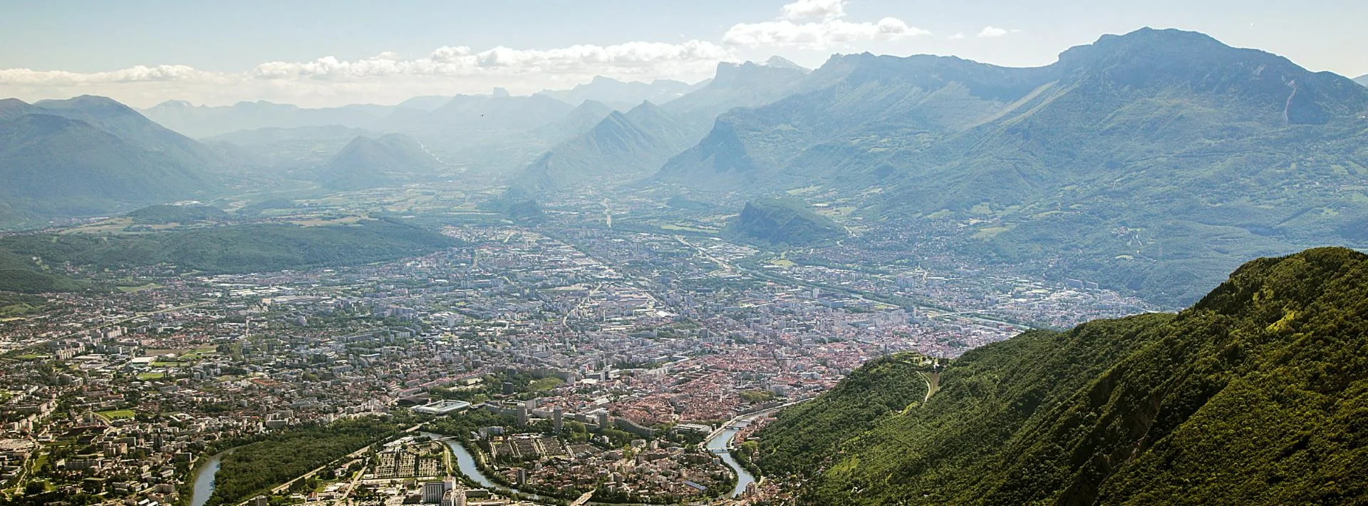 Vue aérienne de Grenoble entourée des montagnes, cadre du campus IPMS.