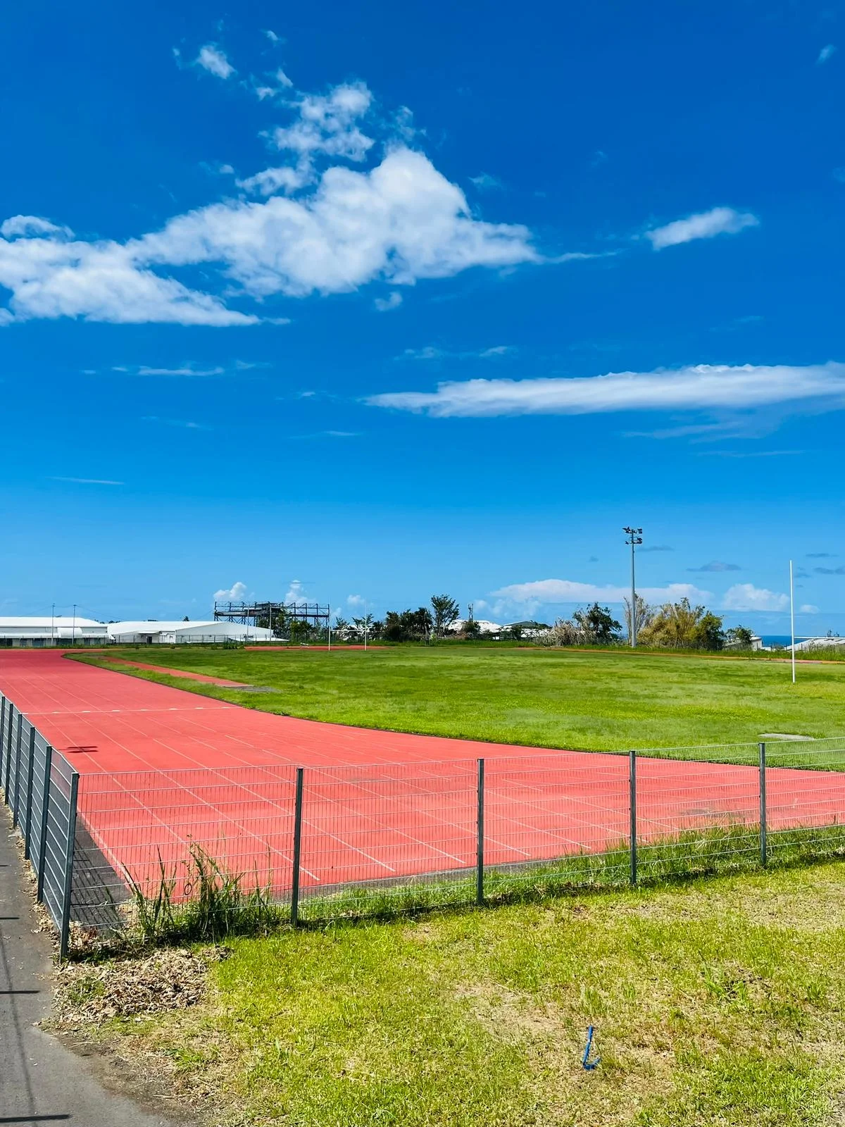 Piste d’athlétisme extérieure rouge du campus IPMS Saint-André, entourée d’espaces verts.