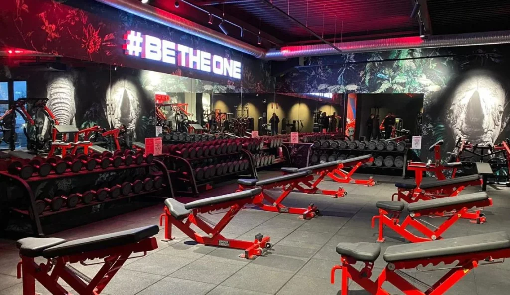 Plateau musculation IPMS Strasbourg équipé de machines rouges et bancs d’entraînement.