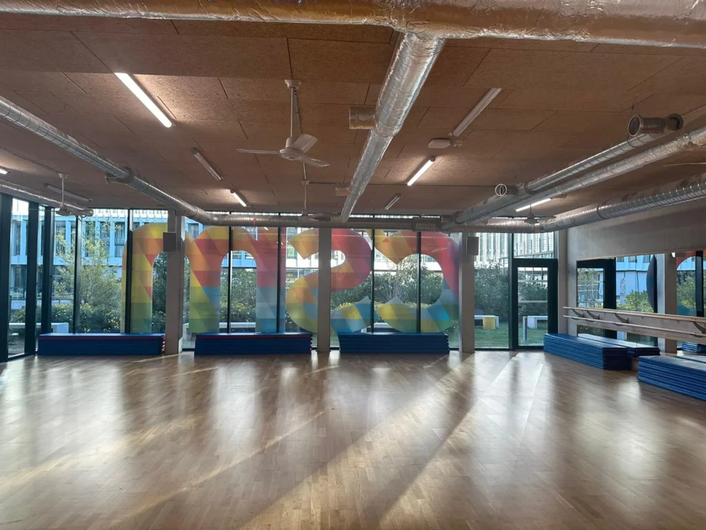 Grande salle multi-activités IPMS Nice avec parquet et miroirs.