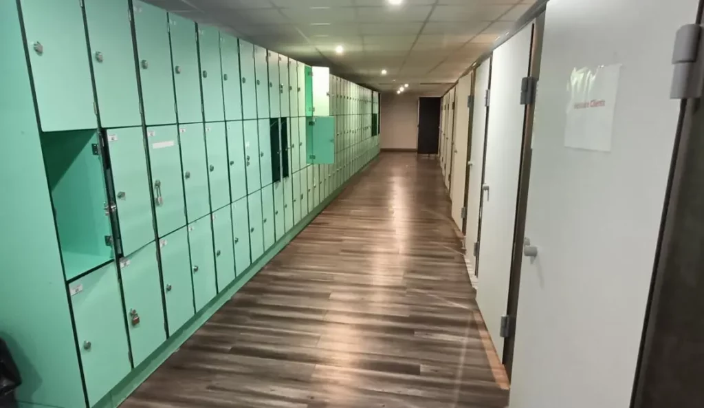 Couloir des vestiaires IPMS Bordeaux avec casiers verts individuels pour étudiants en formation BPJEPS.