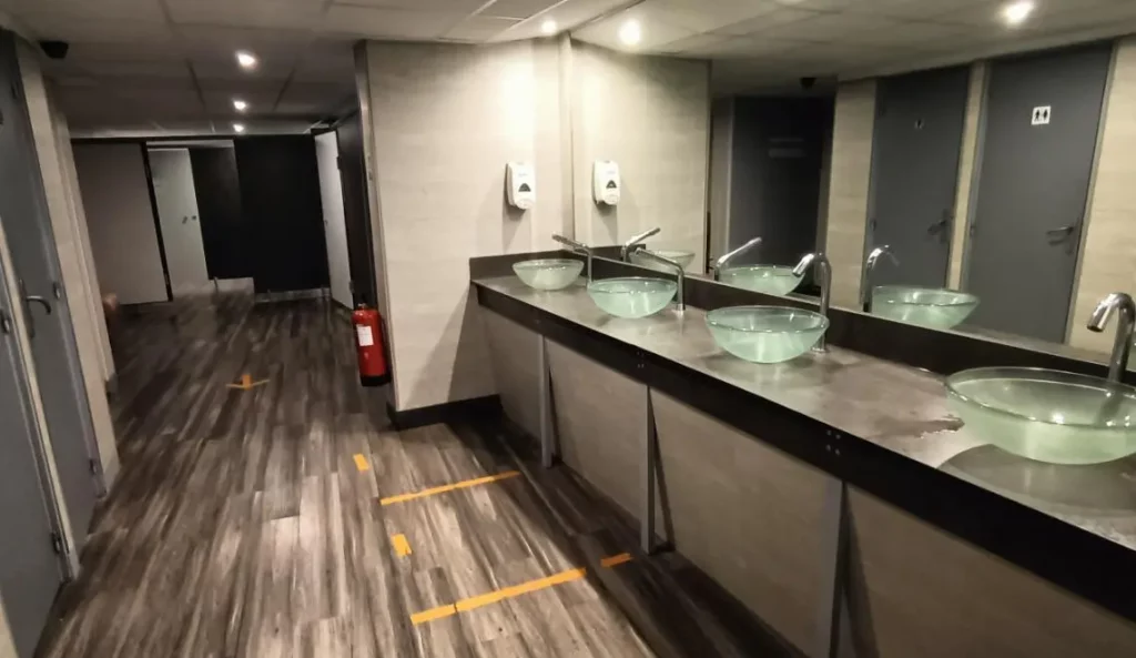 Vestiaires modernes du campus IPMS Bordeaux avec lavabos, miroirs et accès douches pour étudiants BPJEPS.