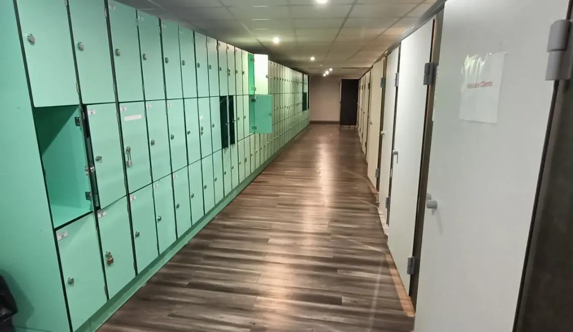 Couloir des vestiaires IPMS Bordeaux avec casiers verts individuels pour étudiants en formation BPJEPS.
