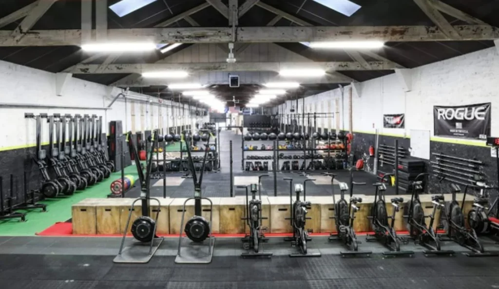 Grande salle de training fonctionnel avec matériel Rogue et équipements de musculation à Lyon.