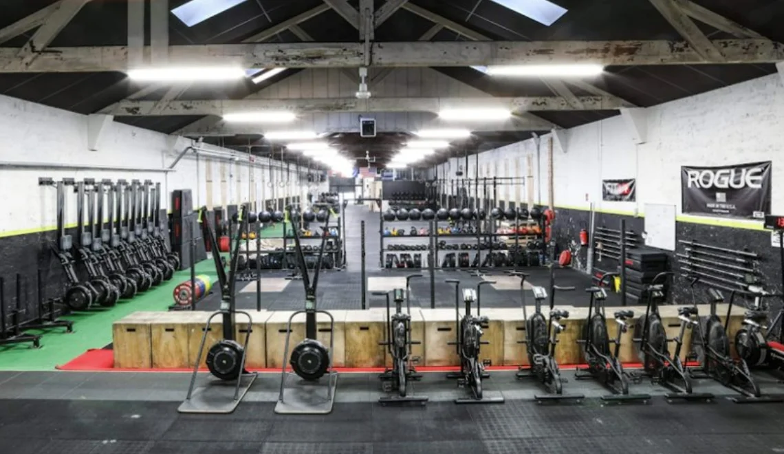 Grande salle de training fonctionnel avec matériel Rogue et équipements de musculation à Lyon.