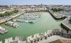 Vue du port de La Rochelle avec les bateaux à quai et les façades typiques du centre historique.
