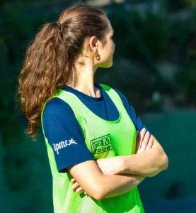 Stagiaire BPJEPS APT de l’IPMS portant une chasuble verte lors d’un atelier d’activités physiques en extérieur.