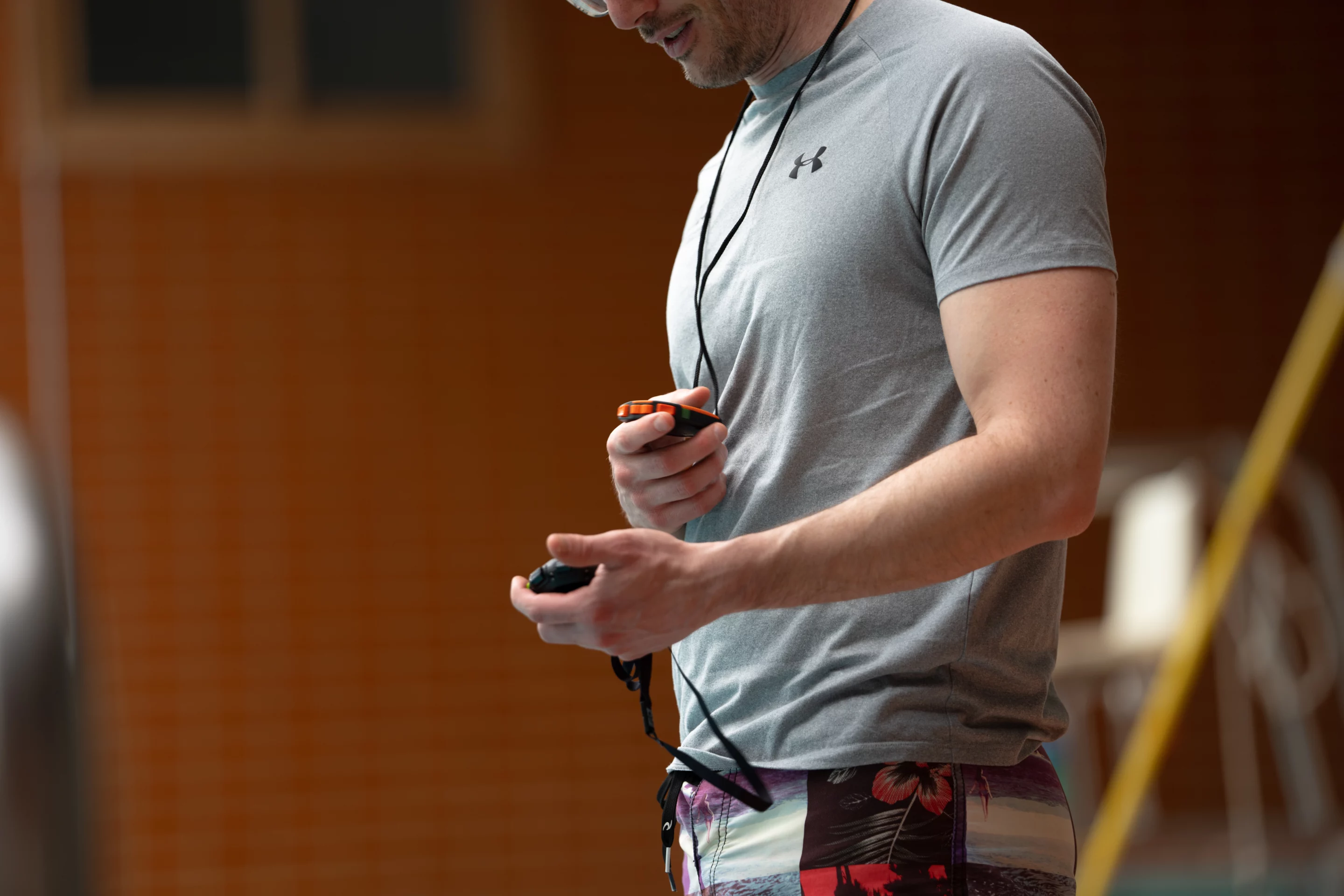 Maître-nageur sauveteur (BPJEPS AAN) au bord du bassin, tenant un chronomètre.