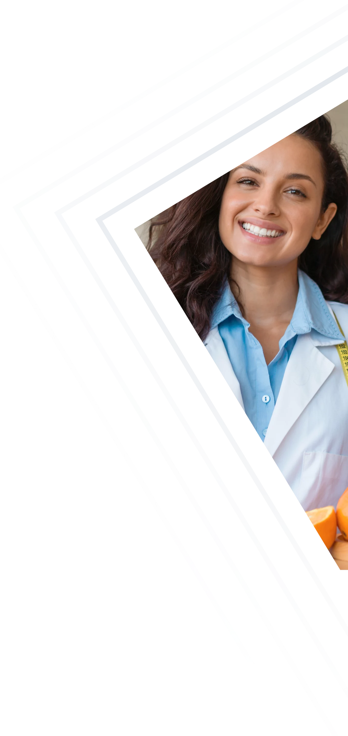 Diététicienne souriante tenant une pomme devant un assortiment de fruits et légumes, illustrant la nutrition santé.