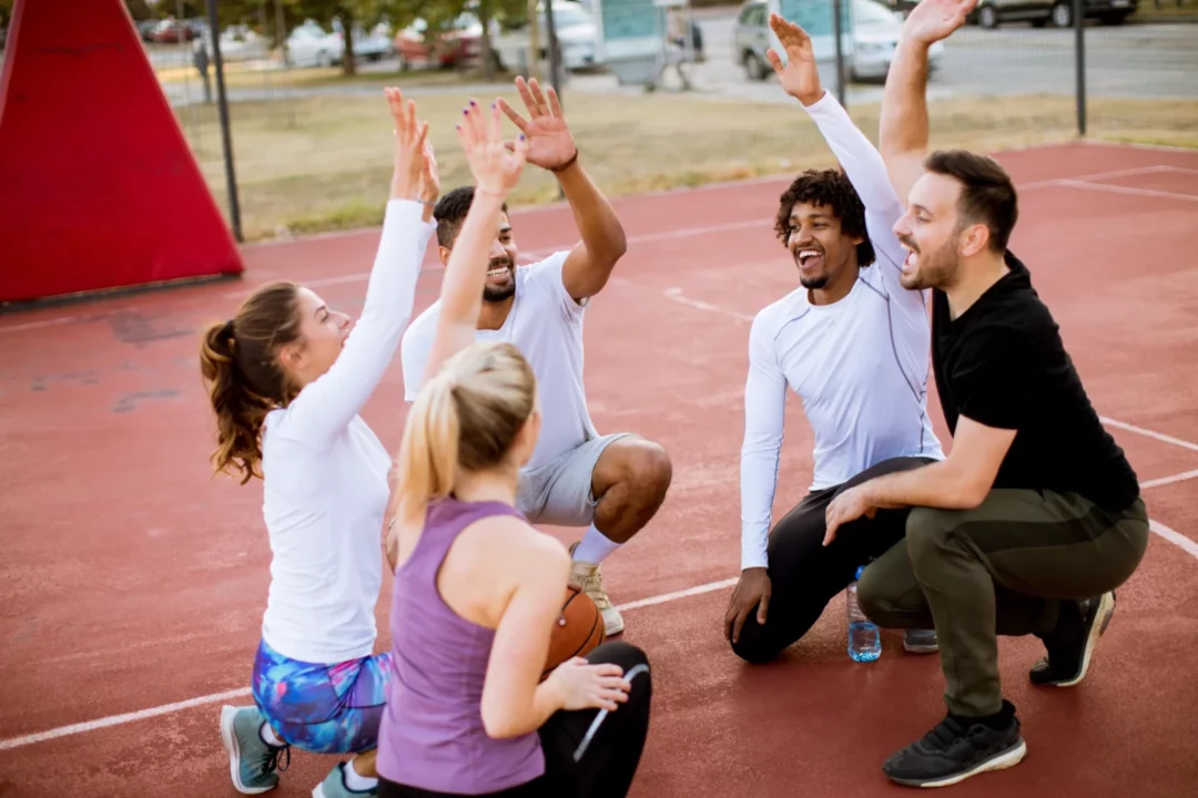 Groupe de participants célébrant ensemble lors d’une activité sportive conviviale en extérieur.
