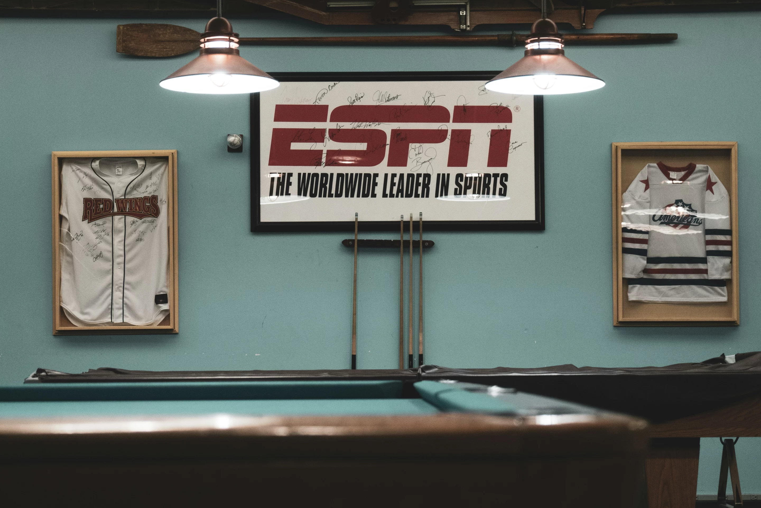 Salle de loisirs décorée avec maillots encadrés et logo ESPN, représentative de l’univers des équipementiers sportifs.